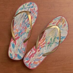 Lilly Pulitzer flip flops with gold thong top and base in pink and teals.